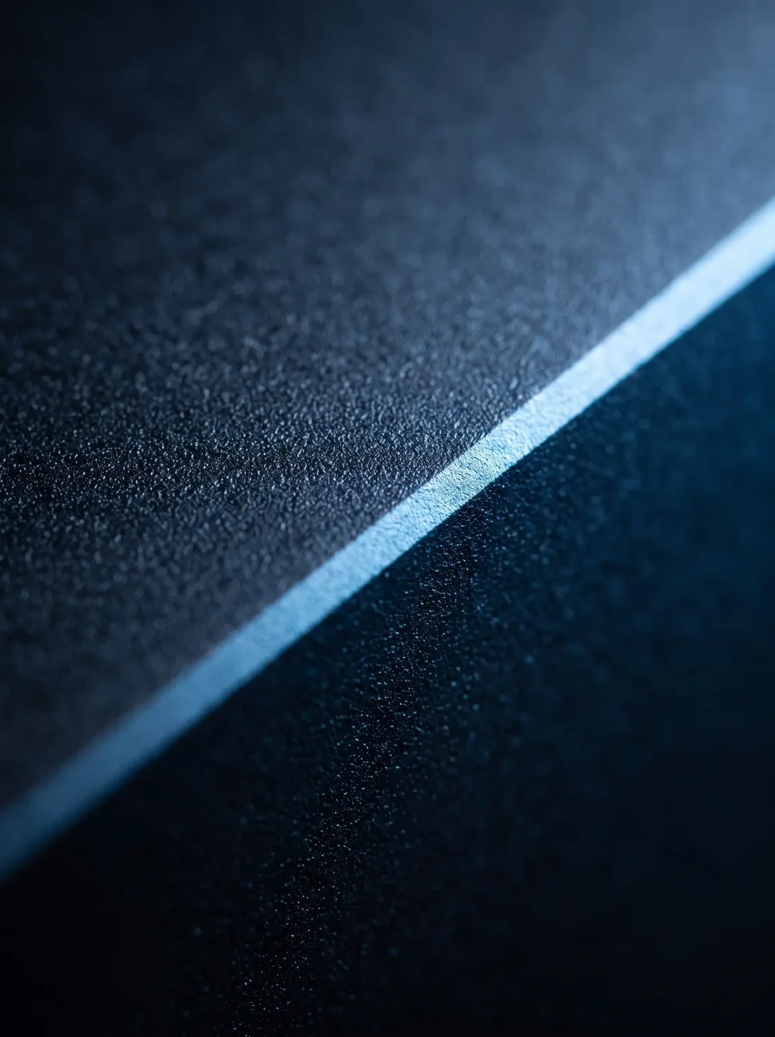 Makroaufnahme einer matten Gehäusekante mit angefaster, hell aufblitzender Lichtkante